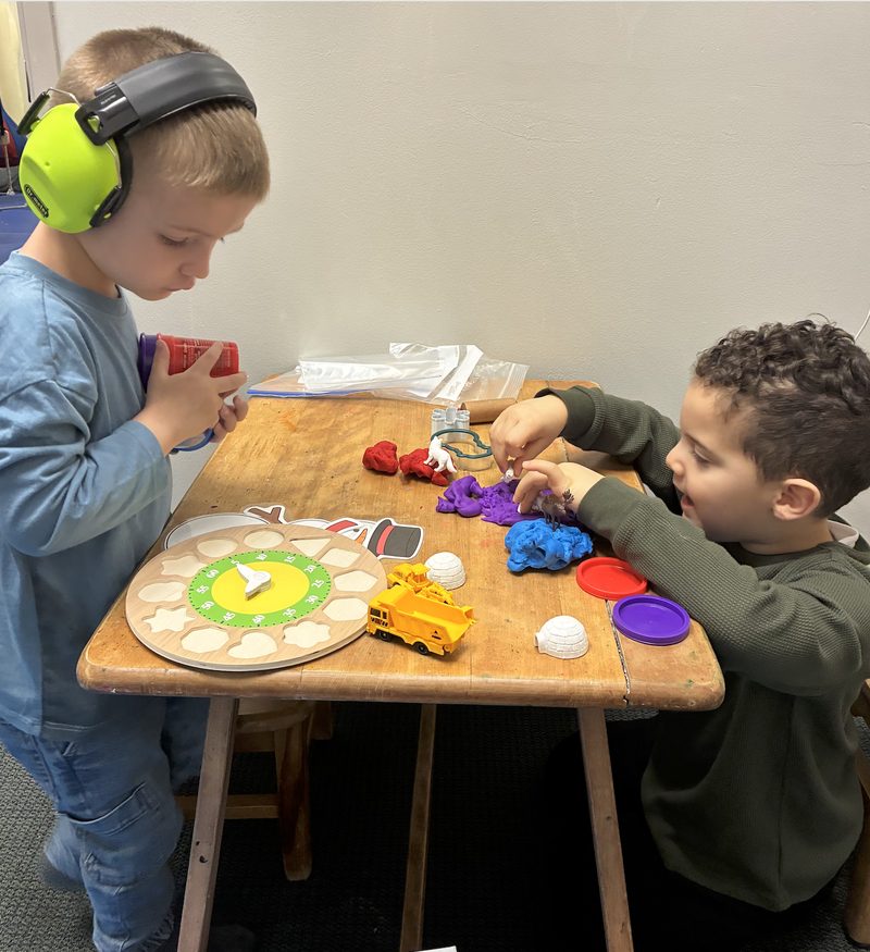 Two children playing together at a table in the Harbor Academy classroom